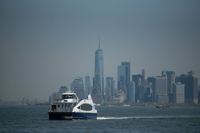 A NYC ferry boat in front of the Lower Manhattan skyline.